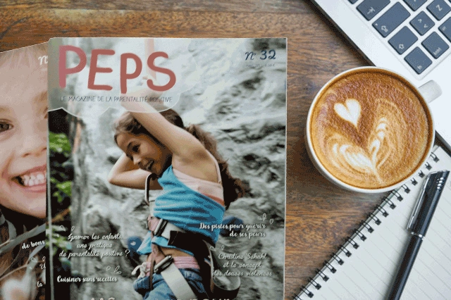 2 numéros de PEPS café, le magazine de parentalité positive, une tasse de café avec un cœur, un cahier, un stylo et un clavier d’ordinateur